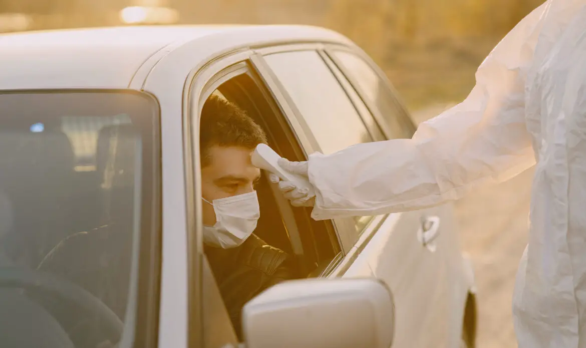 Photo of man getting his temperature by a thermal scanner