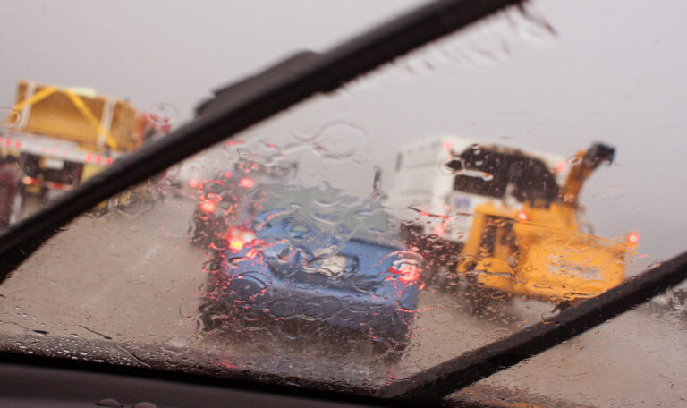 POV Windshield Wipers Displacing Heavy Rain In Rush Hour Traffic