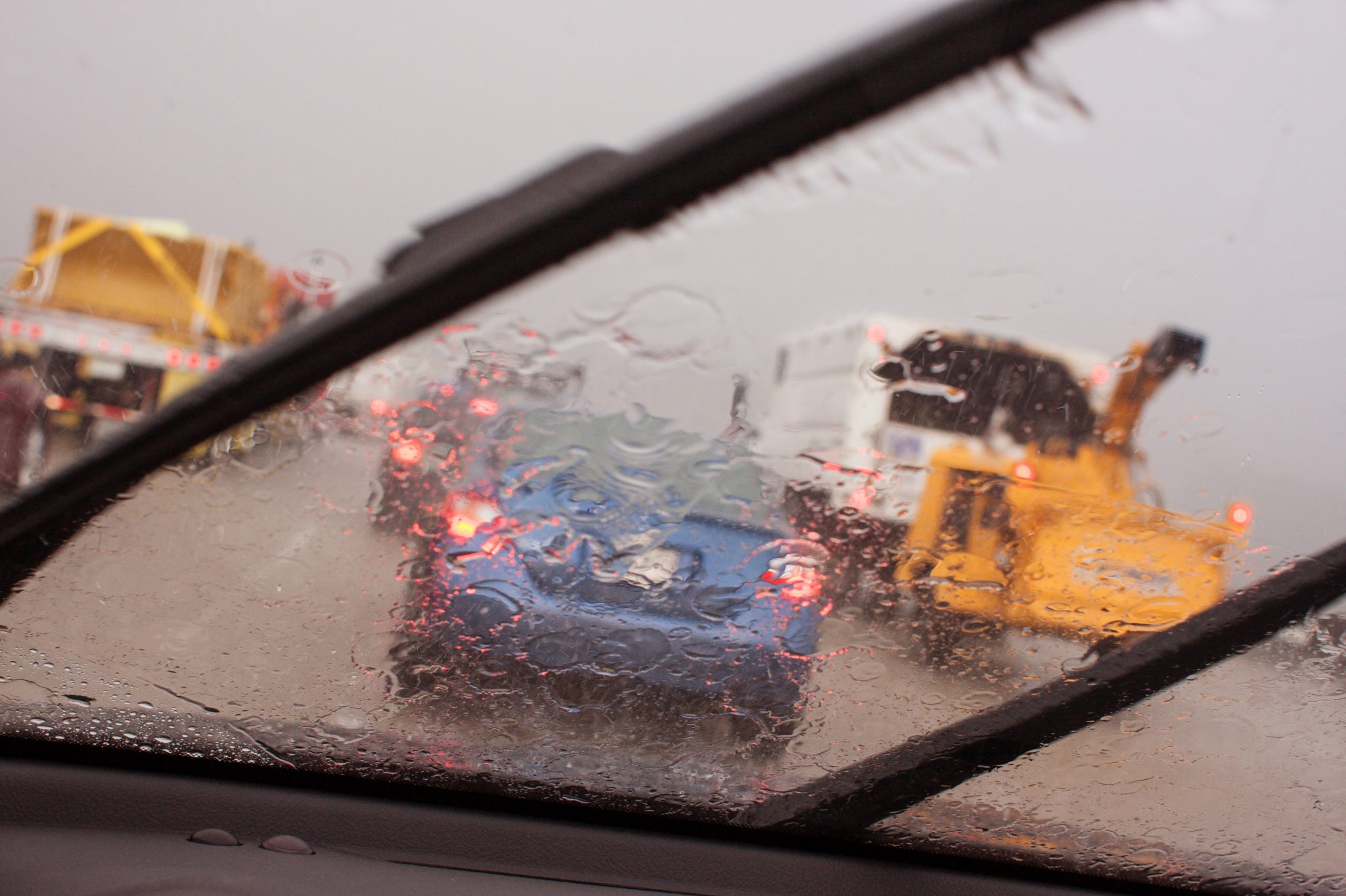 POV Windshield Wipers Displacing Heavy Rain In Rush Hour Traffic