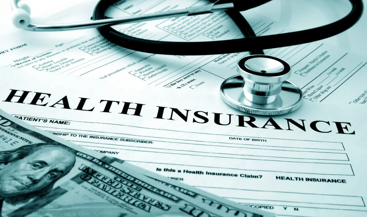 Health insurance form with dollars and stethoscope