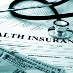 Health insurance form with dollars and stethoscope