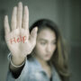 Teenage girl shows help word in dark room