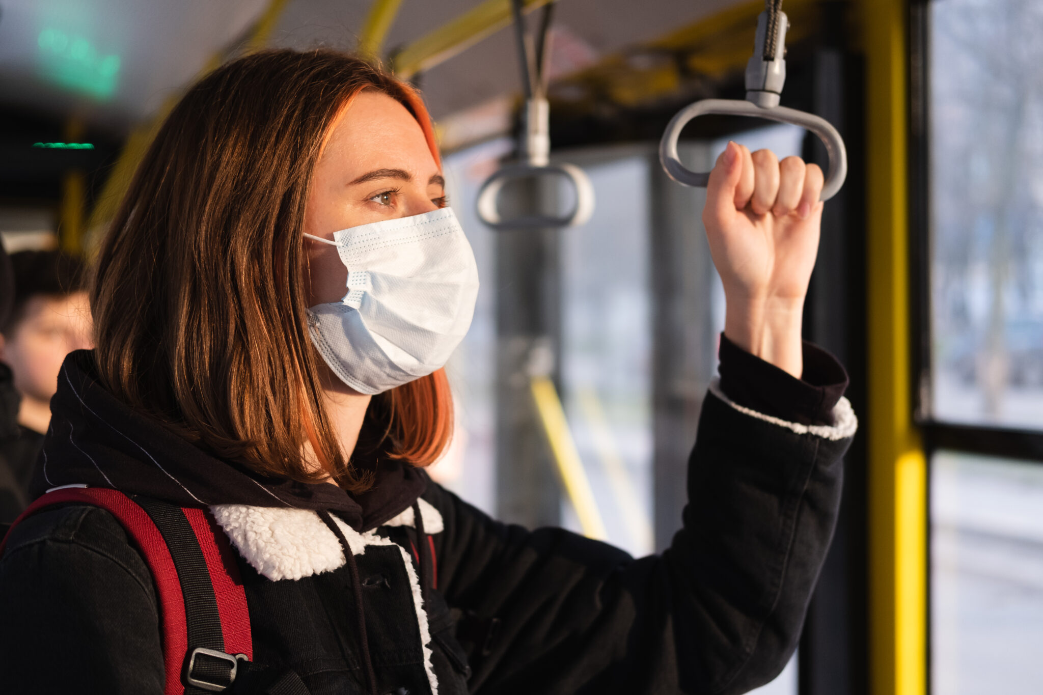 Woman in a protective mask on the train or on the bus. Coronavirus, COVID-19 spread prevention concept, responsible social behaviour of a citizen