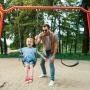 father and son having fun on swing at playground in park