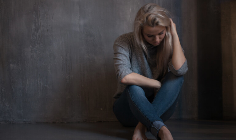 Mental health. Young woman lying on the floor