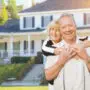 Happy Senior Couple in Front Yard of House