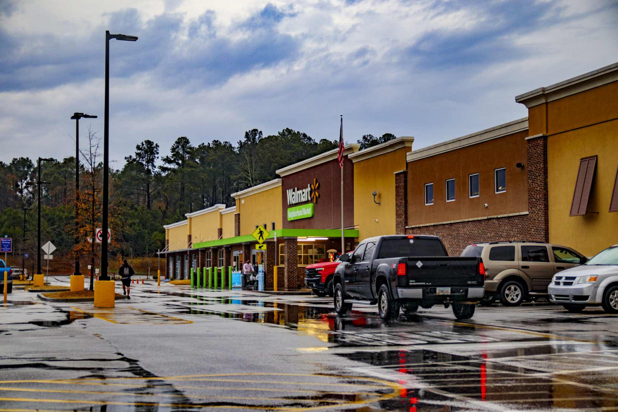 Augusta, Ga USA - 01 01 21: Walmart neighborhood grocery store in the rain with traffic and people