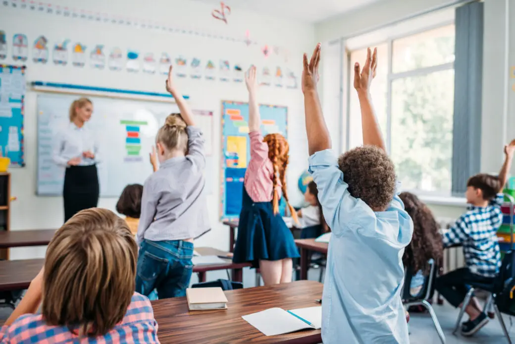 kids raising hands in class