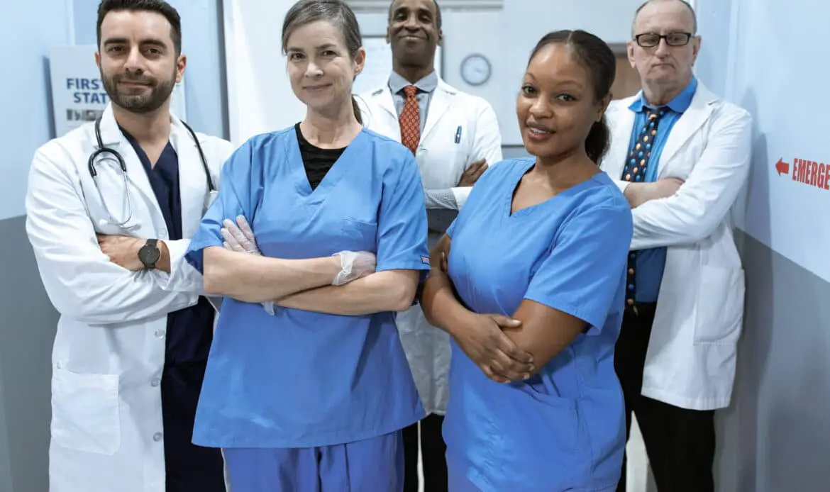 Woman in blue scrub suit standing beside woman in white scrub suit