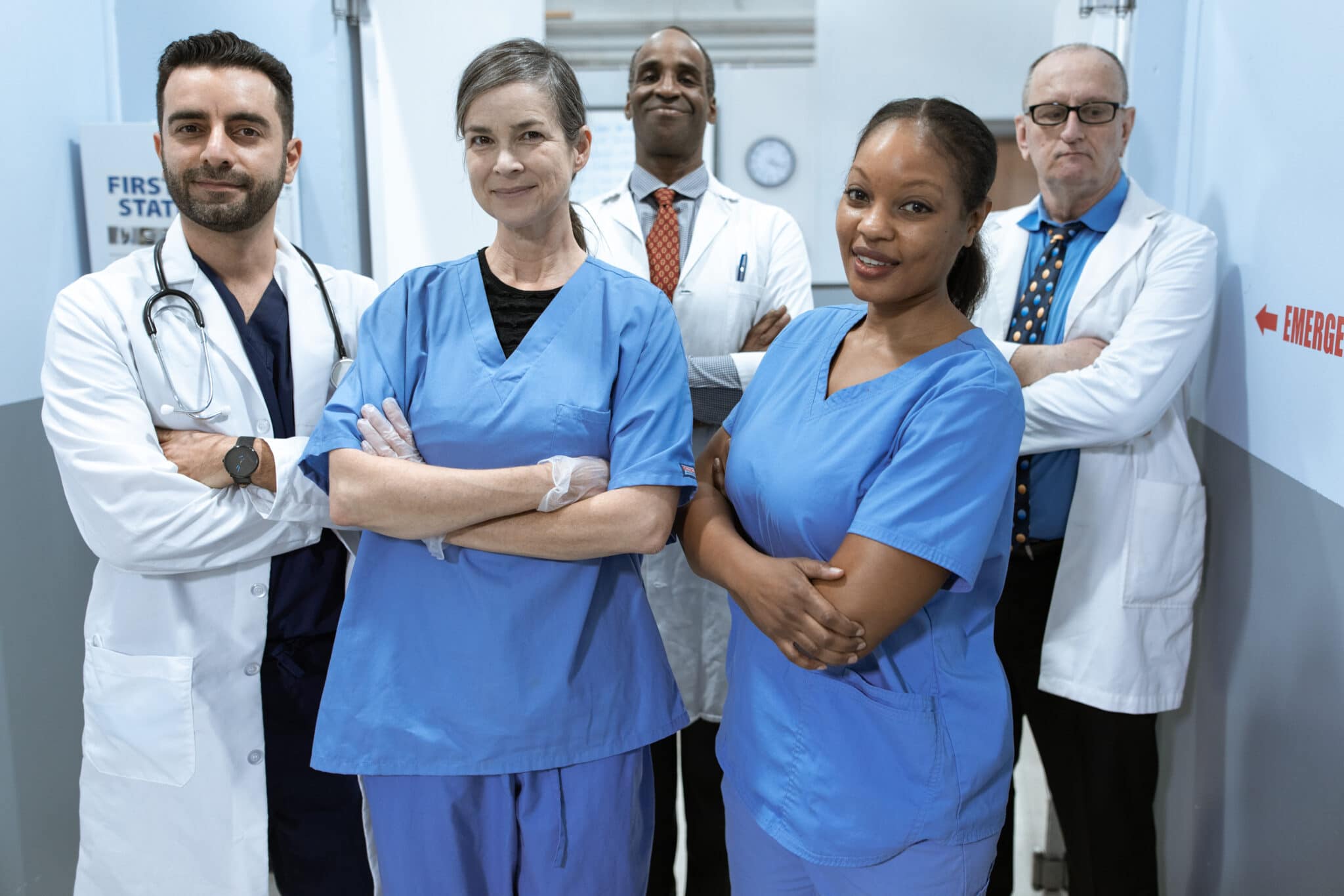 Woman in blue scrub suit standing beside woman in white scrub suit