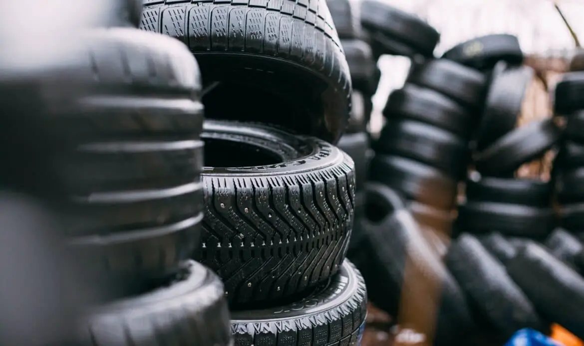 Pile of used tires. Daylight photo with minimum editing. Good for illustration in different kinds of automotive editorials. Model in the center is Goodyear Ultra Grip studded winter tire.