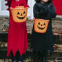 Crop children with buckets in halloween