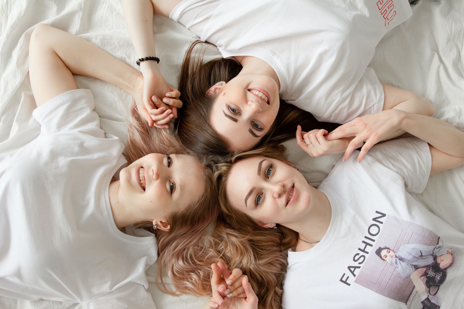 Three Women Lying On Bed
