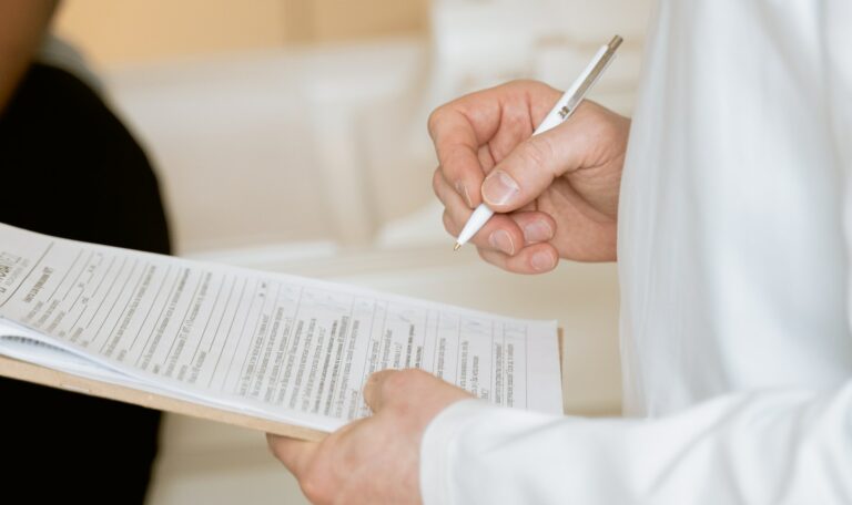 Photo Of Person Holding Paper And Pen