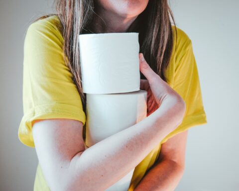 woman in yellow t-shirt holding white tissue paper