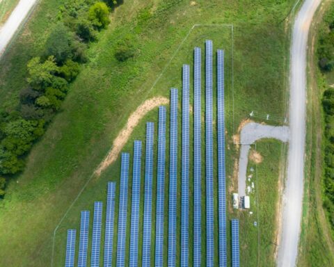 Aerial View of Solar Panels Array on Green Grass
