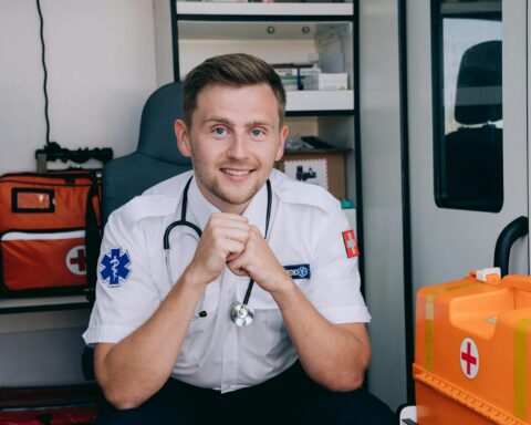 A Paramedic Smiling while Sitting inside an Ambulance