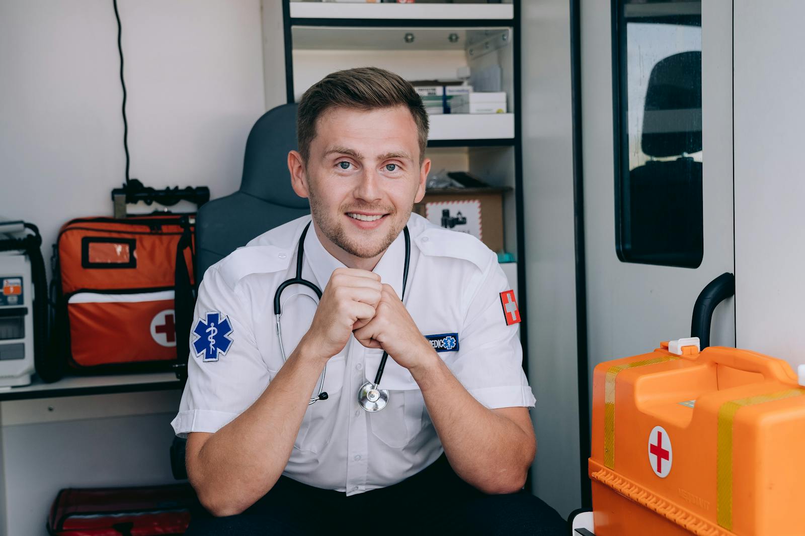 A Paramedic Smiling while Sitting inside an Ambulance