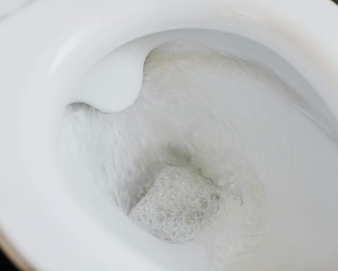 High-angle view of a toilet flushing with swirling water and bubbles, showcasing cleanliness.