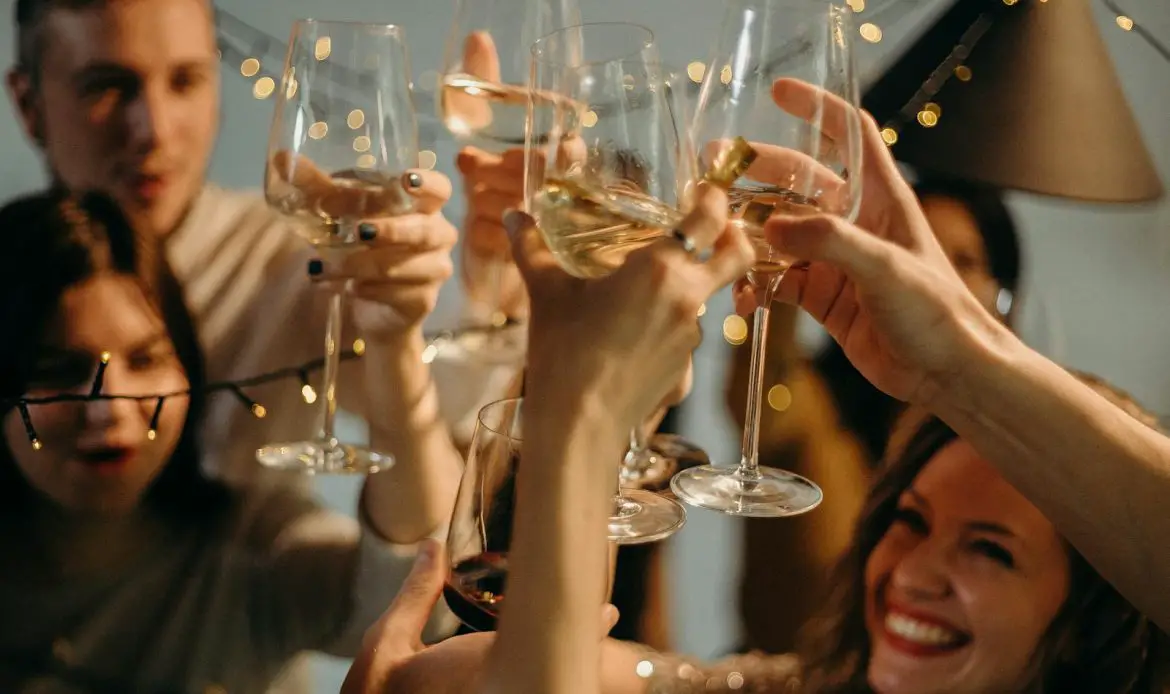 A group of friends joyfully toasting with champagne glasses at a festive celebration.