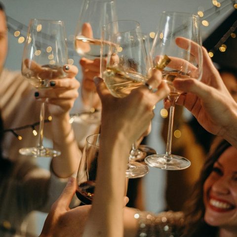 A group of friends joyfully toasting with champagne glasses at a festive celebration.