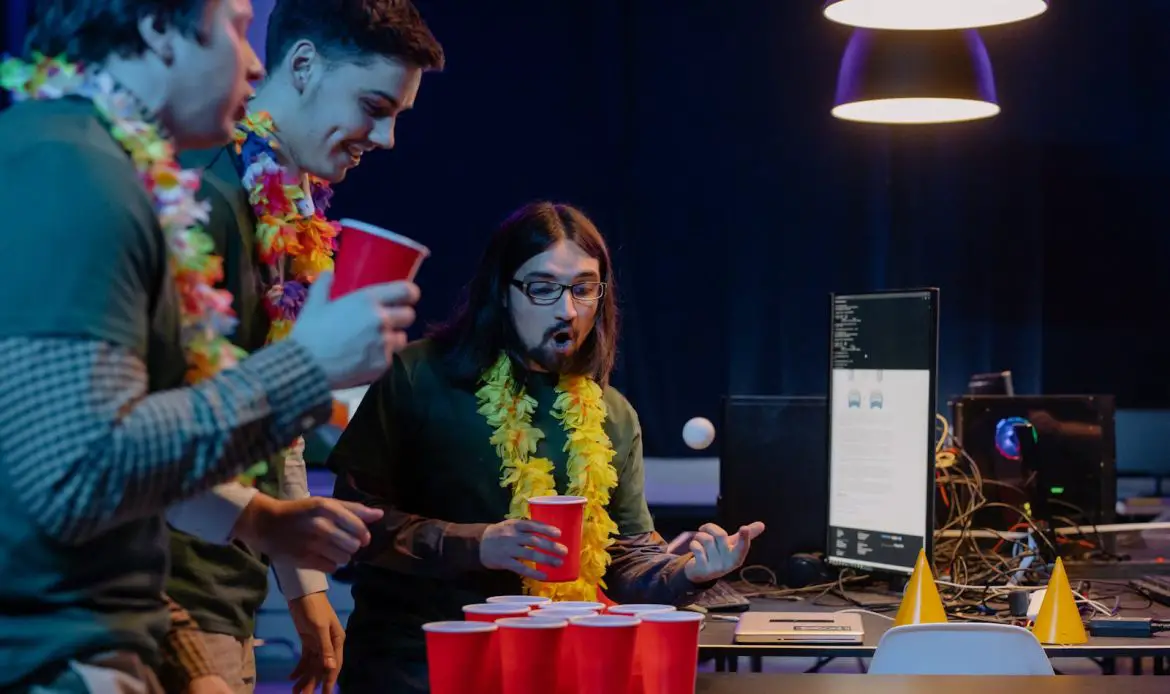 Three men play beer pong indoors, enjoying a lively gathering with red cups and leis.