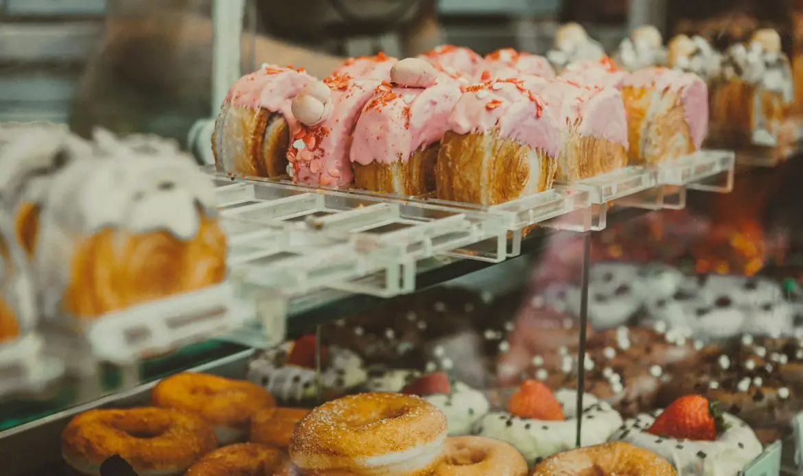 Assortment of vibrant glazed donuts displayed at a bakery in São Paulo, Brazil.