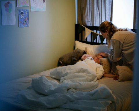 A mother caring for her sick child in a cozy bedroom setting, emphasizing love and comfort.