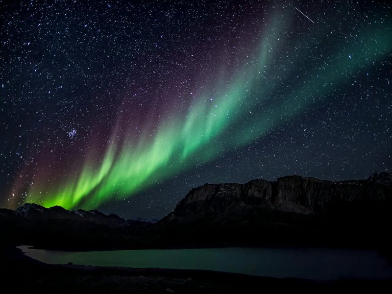 Mesmerizing aurora borealis illuminating the night sky over a serene landscape, capturing nature's beauty.