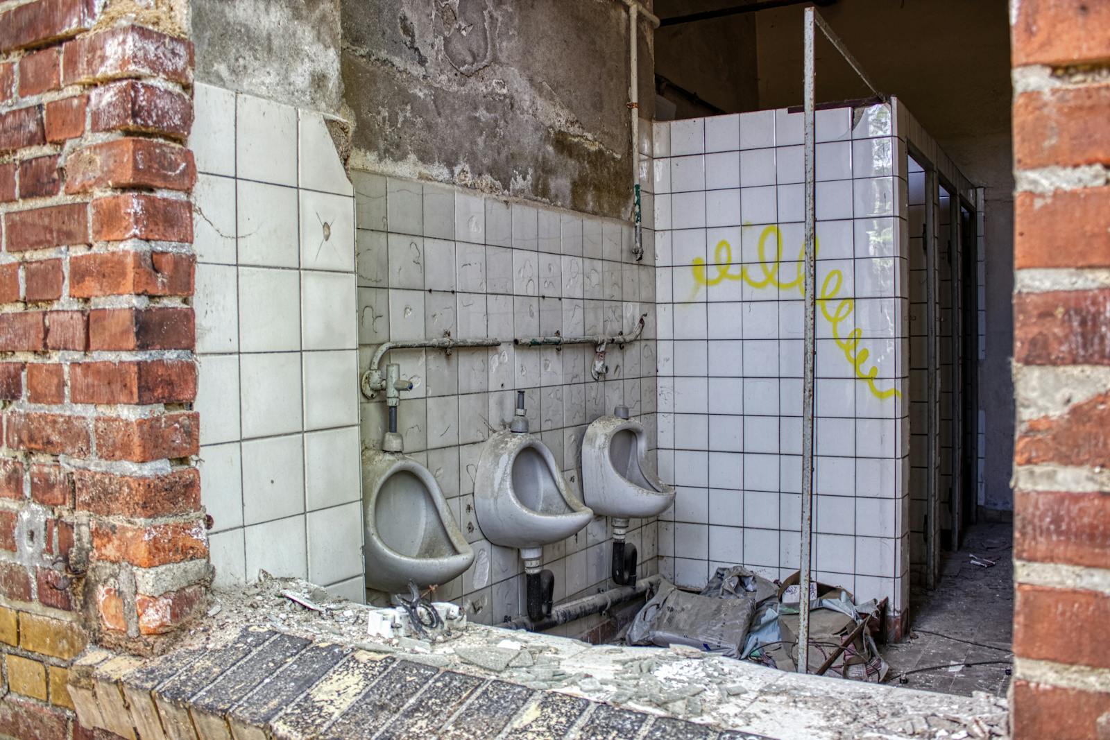 Explore an abandoned restroom with decay and vandalism in Leipzig, Germany.