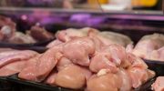 Fresh raw chicken breasts displayed in a supermarket setting, ready for purchase.