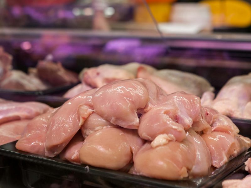 Fresh raw chicken breasts displayed in a supermarket setting, ready for purchase.