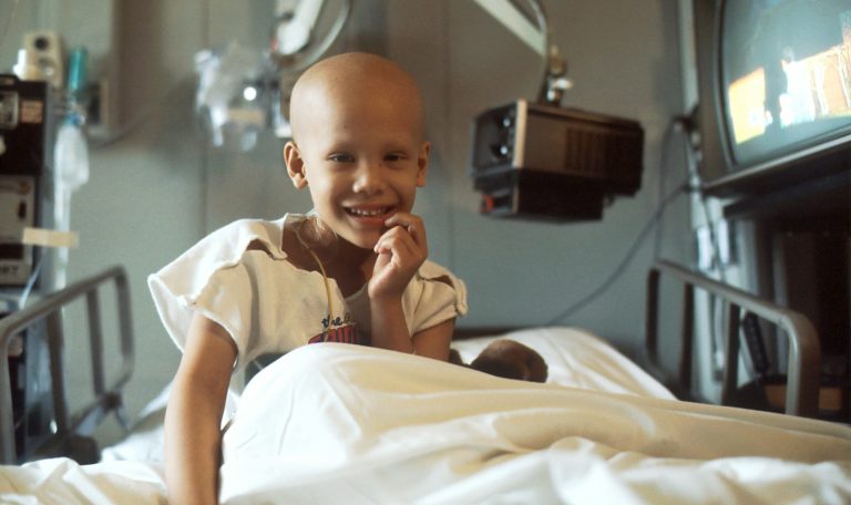 child sitting on bed