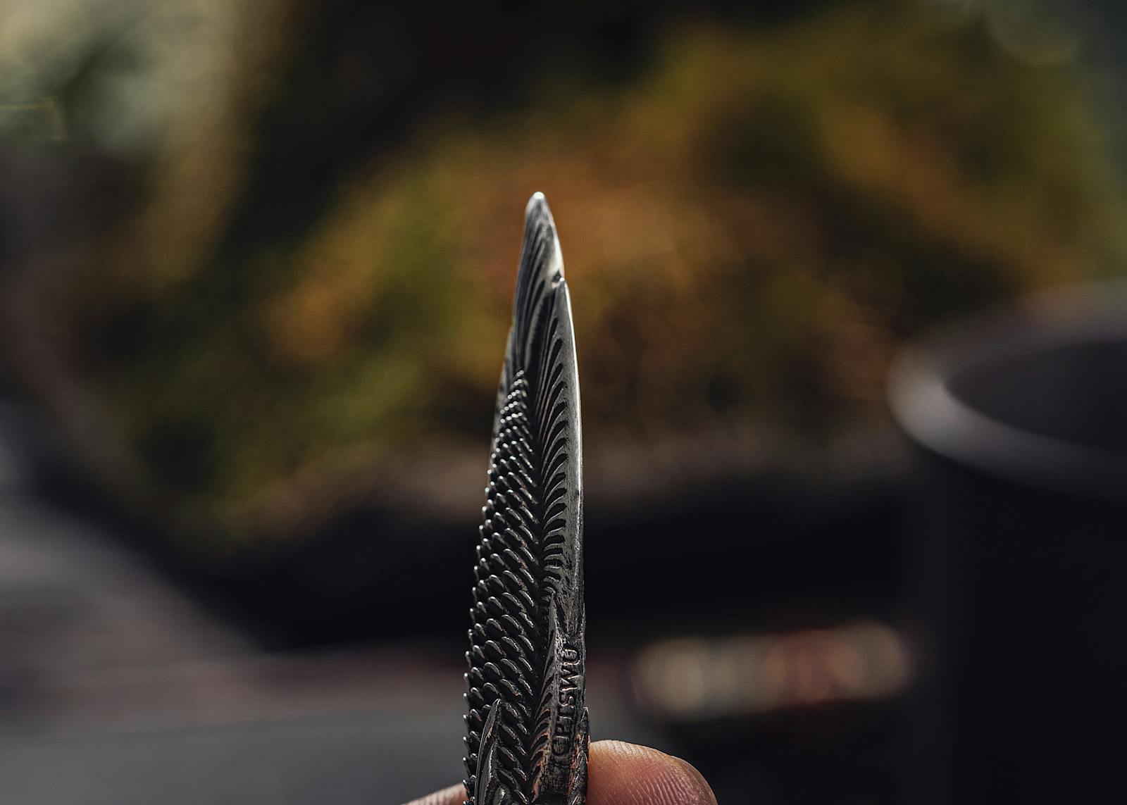 Detailed close-up of a fish-shaped steel box cutter, highlighting its cutting edge and intricate pattern.
