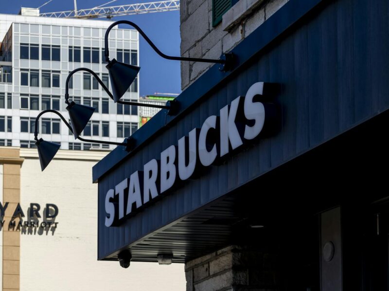 Urban view of a Starbucks storefront and adjacent buildings, sunny day.
