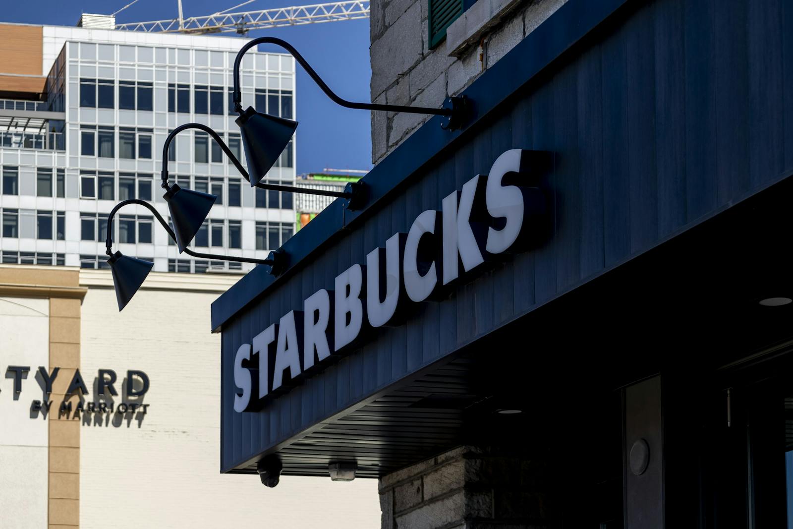 Urban view of a Starbucks storefront and adjacent buildings, sunny day.
