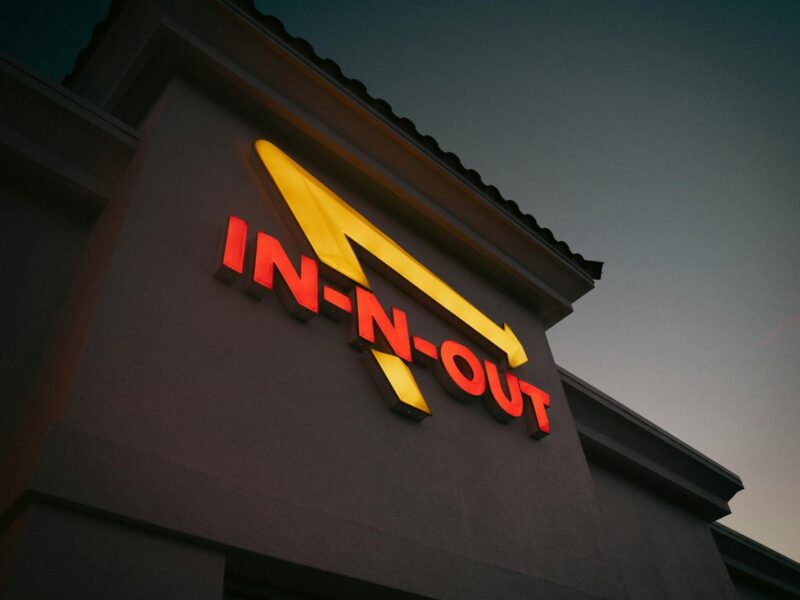 Dramatic shot of In-N-Out Burger sign with vibrant colors at dusk, capturing iconic branding.