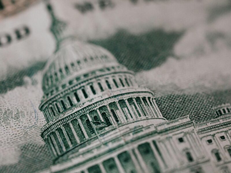 Close-up of the US Capitol illustration on American currency, showing detailed architectural design.