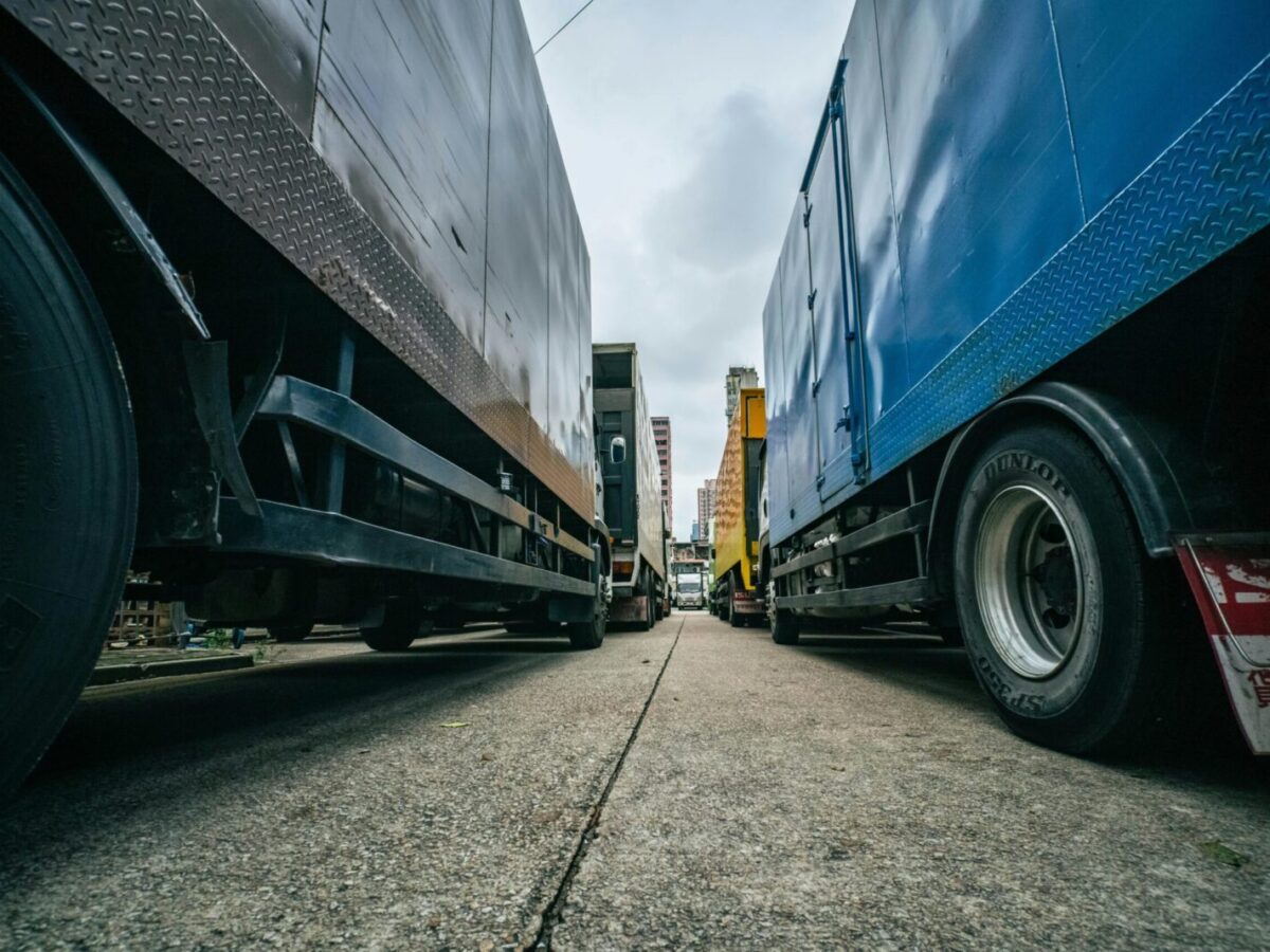 Captivating low-angle perspective of multiple trucks lined up on a street in Hong Kong.
