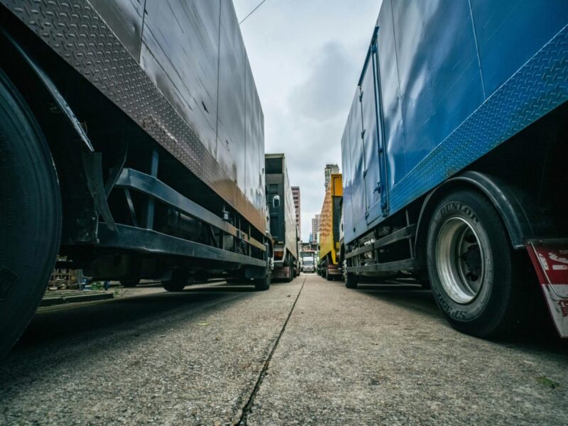 Captivating low-angle perspective of multiple trucks lined up on a street in Hong Kong.