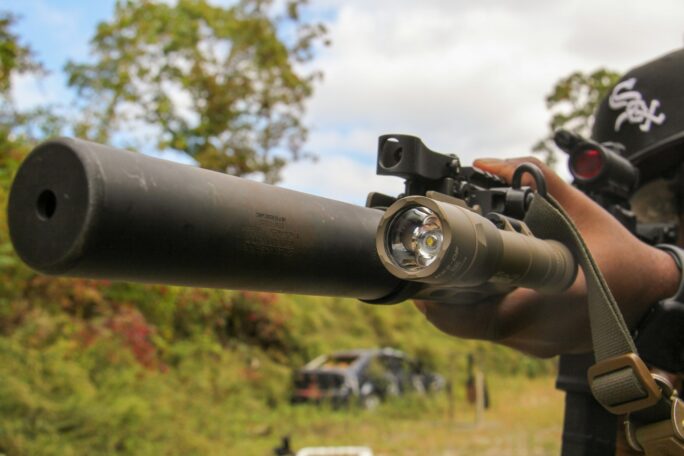 A man holding a rifle and aiming it at something