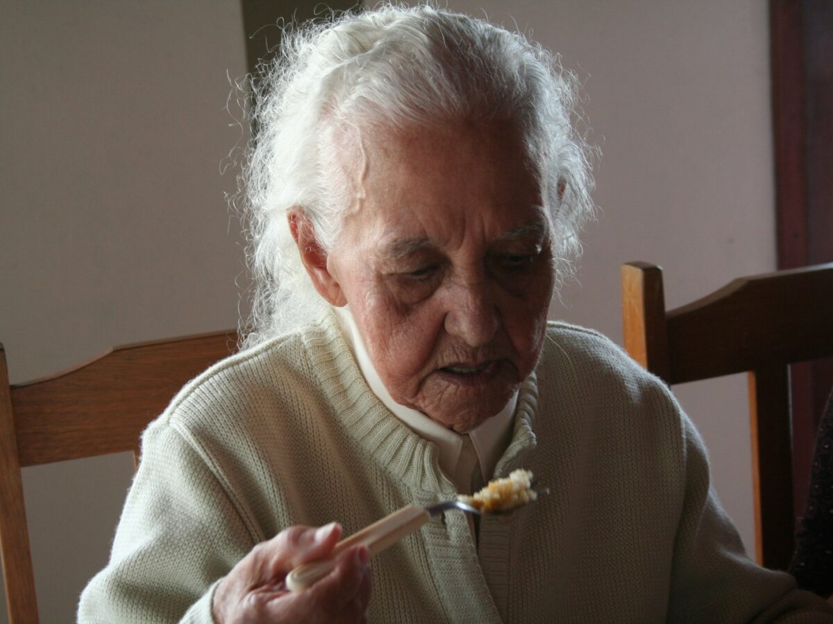 man in white sweater holding fork