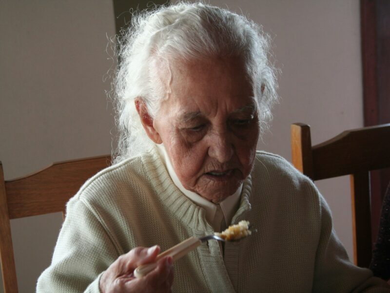 man in white sweater holding fork