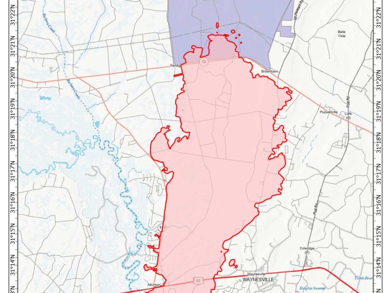 Map showing the wildfire perimeter outlined in red and shaded in light red near Waynesville, Georgia, along Highway 82. The wildfire area covers 20,933 acres as of April 26, 2026. Nearby features include Penholoway Bay to the north, Barber Creek to the west, and various roads such as Atkinson, Post Road, and Mt Pleasant Road. The map includes a scale in miles and a compass rose indicating north.