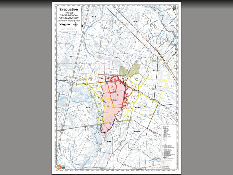 Map titled "Evacuation Hwy 82 GA-GAS-130044 April 30, 2026 Day," showing an evacuation area of 22,577 acres as of April 29, 2026, 2130 hours. The map highlights a central evacuation zone in shades of red and pink, bordered by yellow lines, with numbered sections within the zone. Surrounding areas are labeled with divisions such as Div I, Div J, Div G, Div L, Div M, Div E, Div A, and Branch I. Roads, water bodies, and other geographic features are marked, along with a legend in the bottom right corner indicating various symbols for properties, hazards, and infrastructure. The map includes a scale bar in miles and a north arrow for orientation.