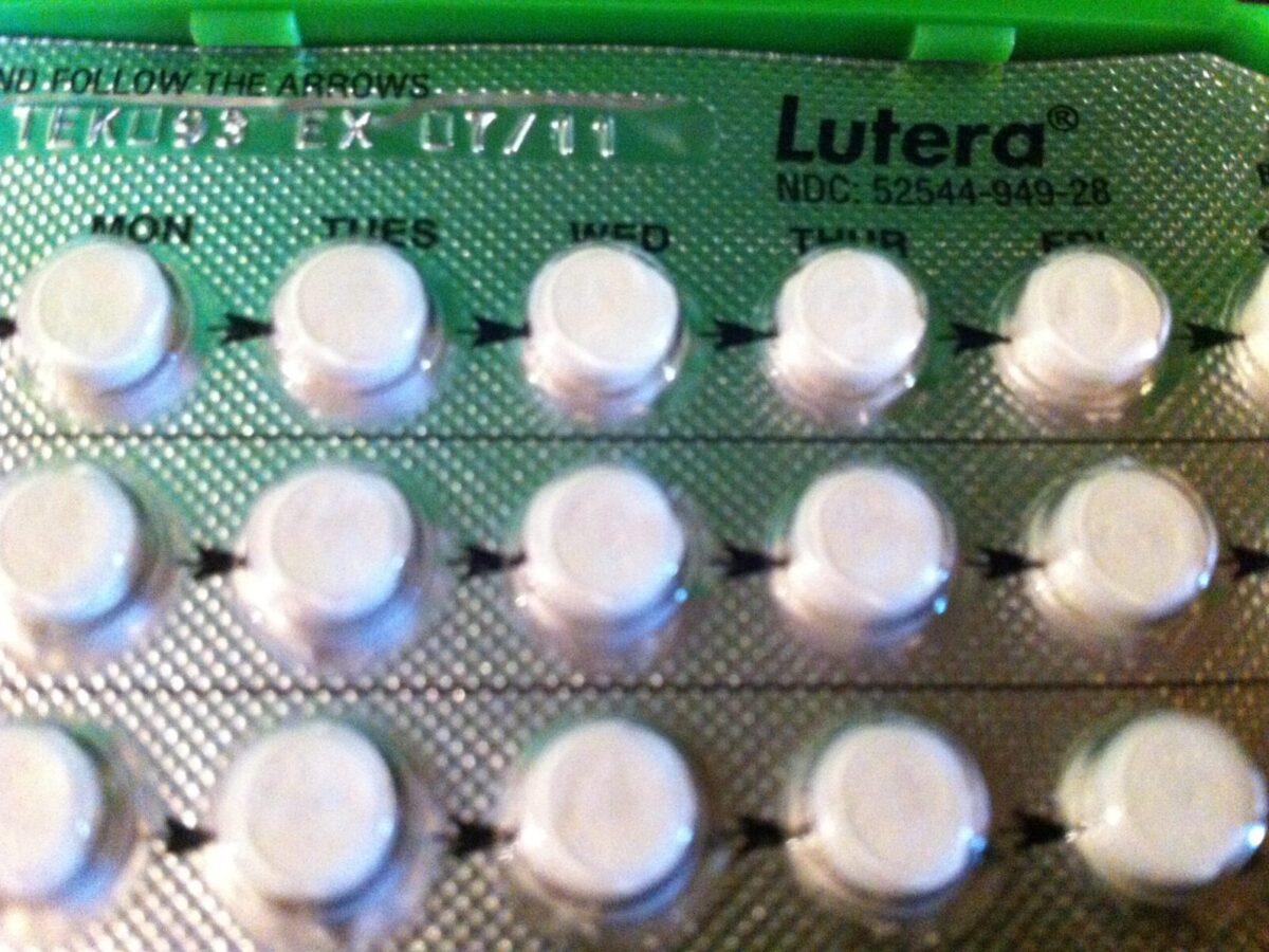 Blister pack of Lutera birth control pills with white round tablets arranged in rows, labeled with days of the week (Mon, Tues, Wed, Thur, Fri) and arrows indicating the order to take the pills. The packaging is silver with black text.