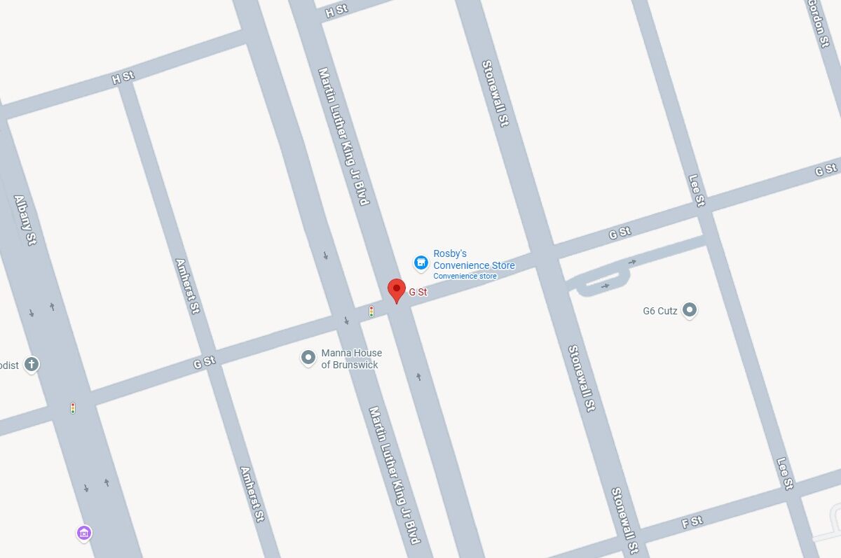 Map showing the intersection of G St and Martin Luther King Jr Blvd, with nearby streets including Albany St, Amherst St, Stonewall St, Lee St, Gordon St, Wolfe St, and H St. Notable locations marked are Rosby's Convenience Store, Manna House of Brunswick, Grace United Methodist, and G6 Cutz. Traffic lights are indicated at some intersections.