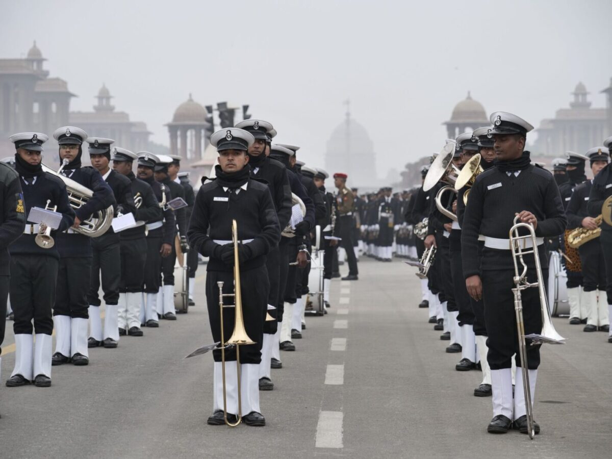 Military band performing in formal uniforms on a city street in Delhi, India.