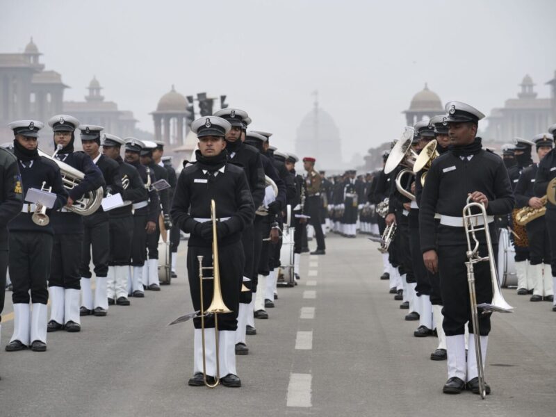 Military band performing in formal uniforms on a city street in Delhi, India.
