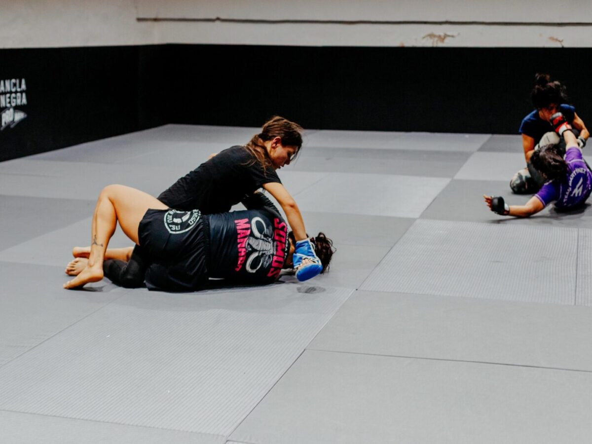 Female martial artists training at a gym in Buenos Aires, showcasing skill and strength.